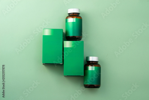 Green supplement bottles and boxes mockup on a clean white background.