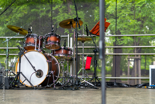 Fotografía Professional drum kit with sunburst wooden shells set up on an outdoor stage, fe