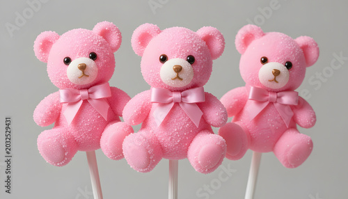 Adorable teddy bear cake pops with pink bows isolated on soft background. Cute sweet dessert concept for birthdays, baby showers, and bakery designs.
