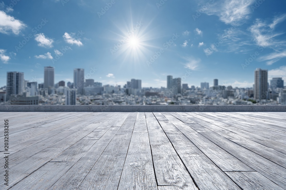 Fototapeta premium Bright Sunny Day Overlooking a Modern Cityscape with a Wooden Deck in the Foreground