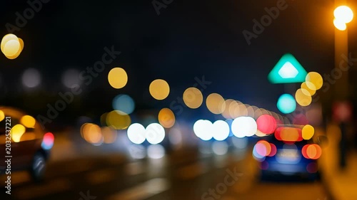 Blurred nighttime city traffic with glowing bokeh lights and cars in the distance. 4k Video footage.