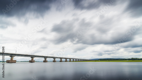 Fotografie Mekong River Bridge Crossing in Laos with Dramatic Sky