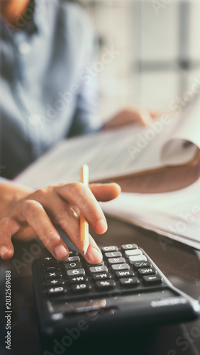 Close-up view woman's hand using a calculator