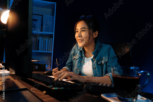 Canvastavla Smiling young beautiful asian creative officer looking on pc in sales target online, earning job's freelancer for planning invest new strategy marketing online planning at neon light night