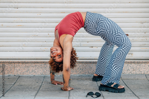 girl on the street with elasticity and acrobatics pose