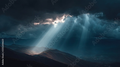Dramatic clouds and sunbeams breaking through stormy sky over mountain landscape during rainstorm