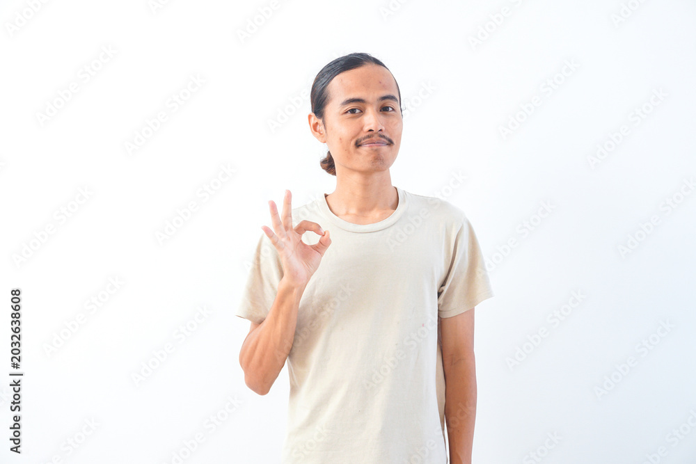 Naklejka premium Young Asian man in a shirt, give OK or approved sign expression. Isolated in white background