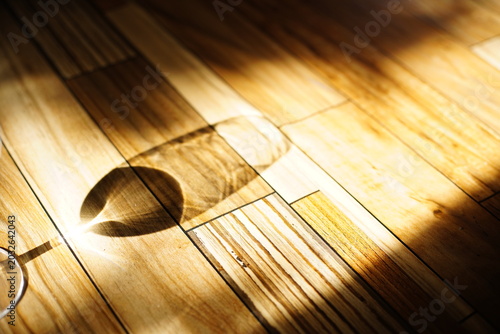 Warm sunlight and abstract glass shadow on wooden floor background