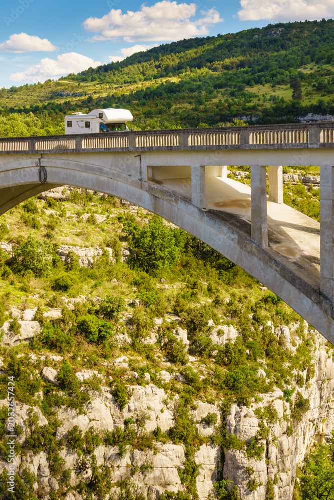 Fototapeta premium Caravan visiting Verdon Gorge in French Alps with Chauliere Bridge over the Artuby river, France.
