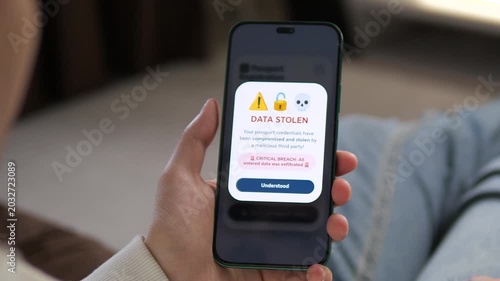Critical data breach. A smartphone displays a Data Stolen alert after a malicious hack. Perfect for cybersecurity news, identity theft stories, and online safety campaigns. High-impact footage of a