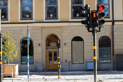 Tableau sur toile Traffic lights with pedestrian signal in front of a building displaying the numb
