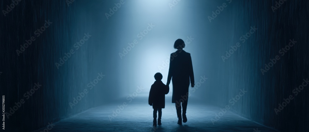Fototapeta premium Woman holding child hand while walking through dark evacuation tunnel