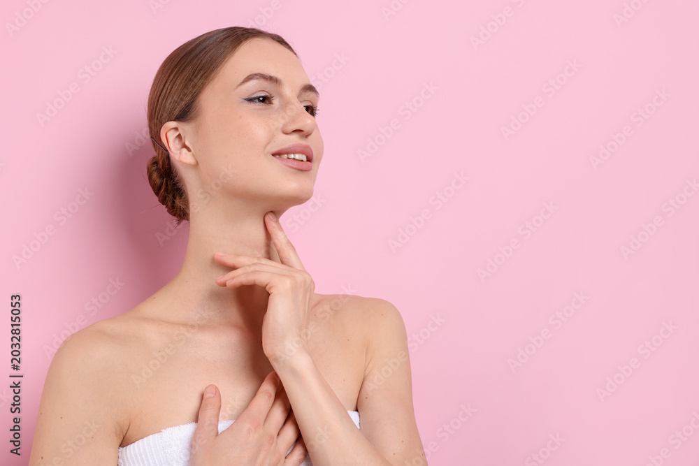 Fototapeta premium Beautiful woman touching her neck on pink background. Space for text