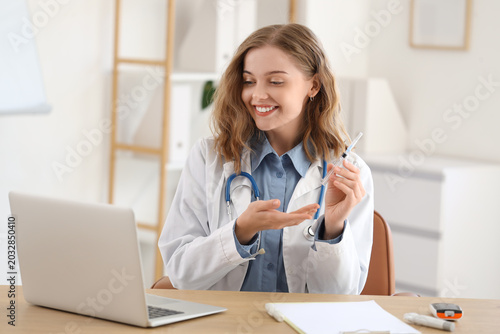 Female doctor with insulin injection giving online consultation in office