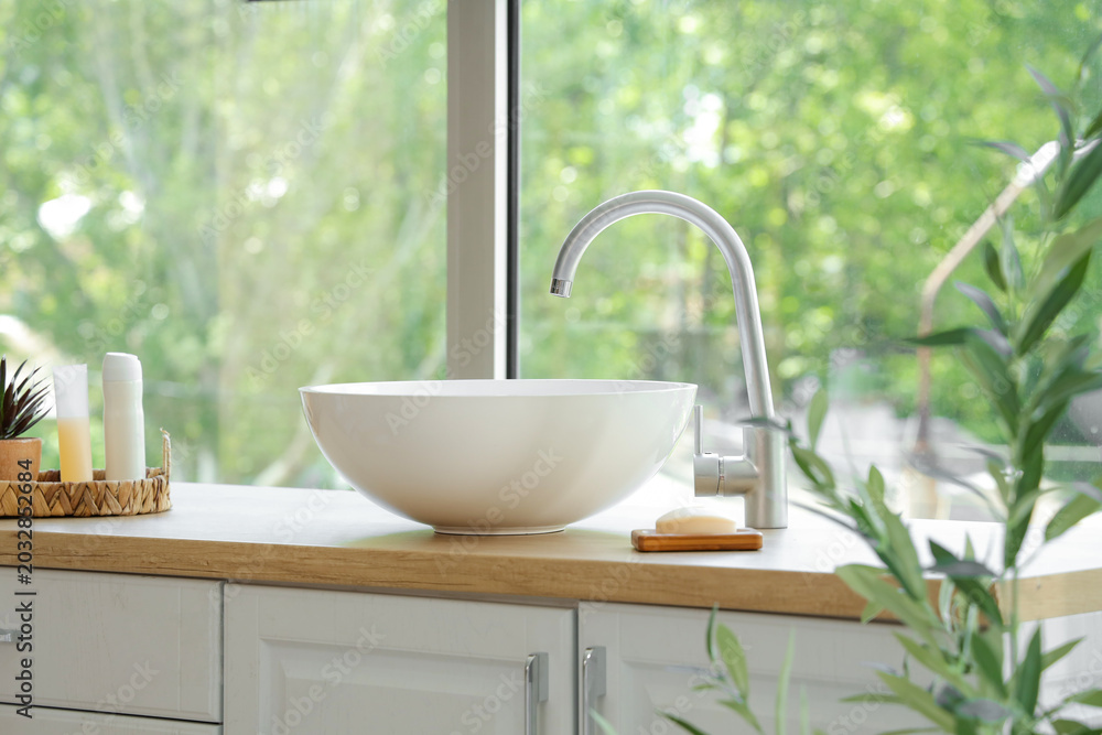 Fototapeta premium Stylish sink and decorative olive tree in modern bathroom