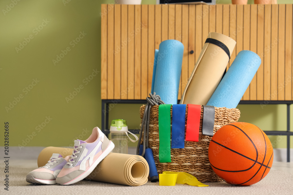 Naklejka premium Sports equipment with sneakers on carpet in living room