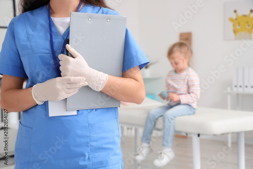 Pediatric nurse holding cli...