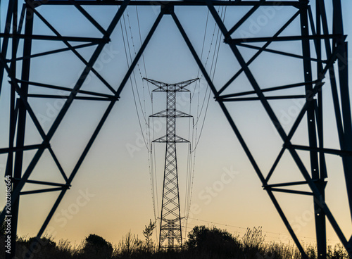 Landscape with high-voltage towers at sunset