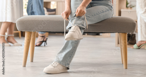 Woman tying shoe laces in b...