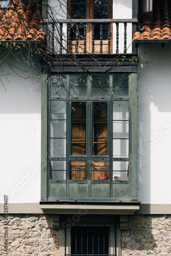 Traditional Asturian house featuring glazed balcony and stone wall