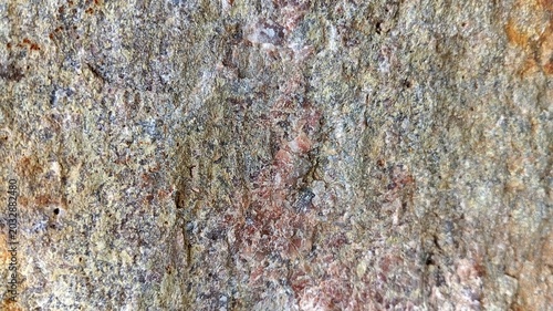 Фотография Close-up of weathered geological rock surface with translucent quartz crystals, pink feldspar and grey mineral structure