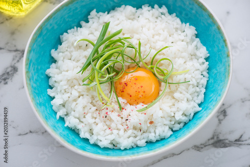 Foto Turquoise bowl with tamago kake gohan or white rice mixed with a raw chicken egg