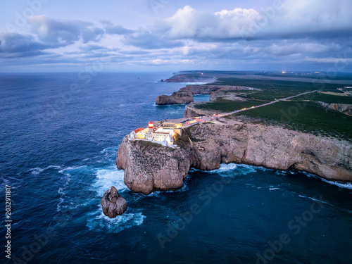 Drone view of the Lighthouse of Cabo de Sao Vicente in Sagres, Algarve, Portugal, at evening with shoreline surf and Atlantic ocean