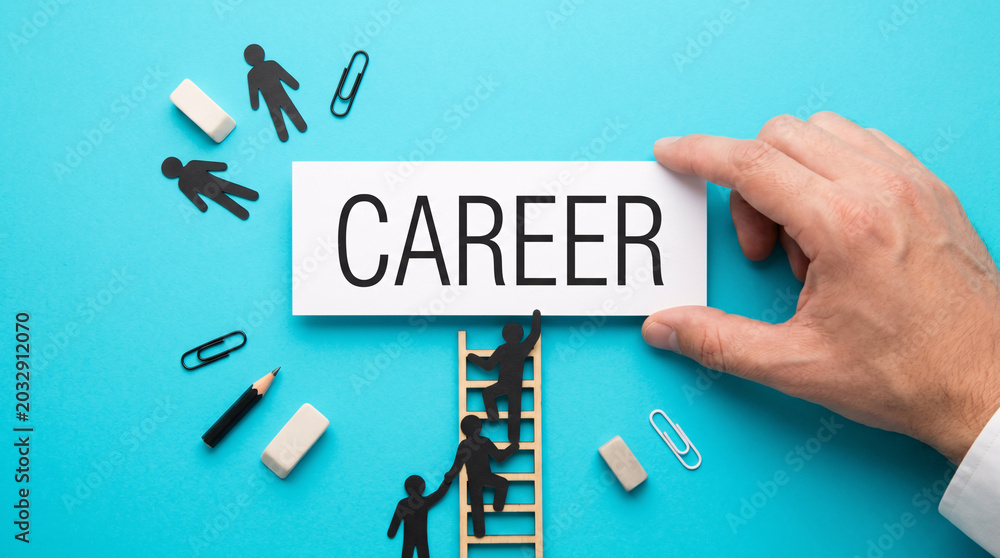 Fototapeta premium Hand holds CAREER sign above ladder. Mini figures climb toward success. Tools scatter around symbolic workspace