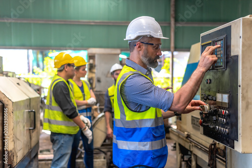 Valokuva Male factory engineer checking and working on control box in industrial factory