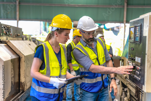 Φωτογραφία Caucasian male engineer briefing work to female technician about control box sys