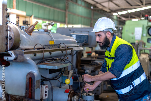 Bilde på lerret Expertise male factory engineer working with heavy machinery in industrial facto