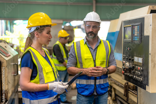 Valokuva Caucasian male engineer briefing work to female technician about control box sys