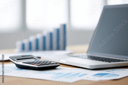 Business office desk with laptop, calculator and financial graphs, corporate budgeting and expense tracking