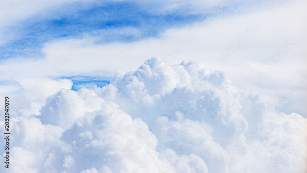 Fototapeta premium White clouds float in blue sky during daytime over open area on a clear day with no visible obstacles
