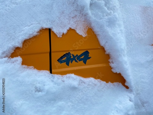 4x4 in the snow — orange off‑road vehicle panel on a winter day