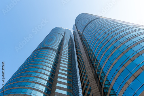 Low angle view of modern skyscrapers against clear blue sky in financial district, showcasing urban architecture, business growth, corporate environment and future city development concept