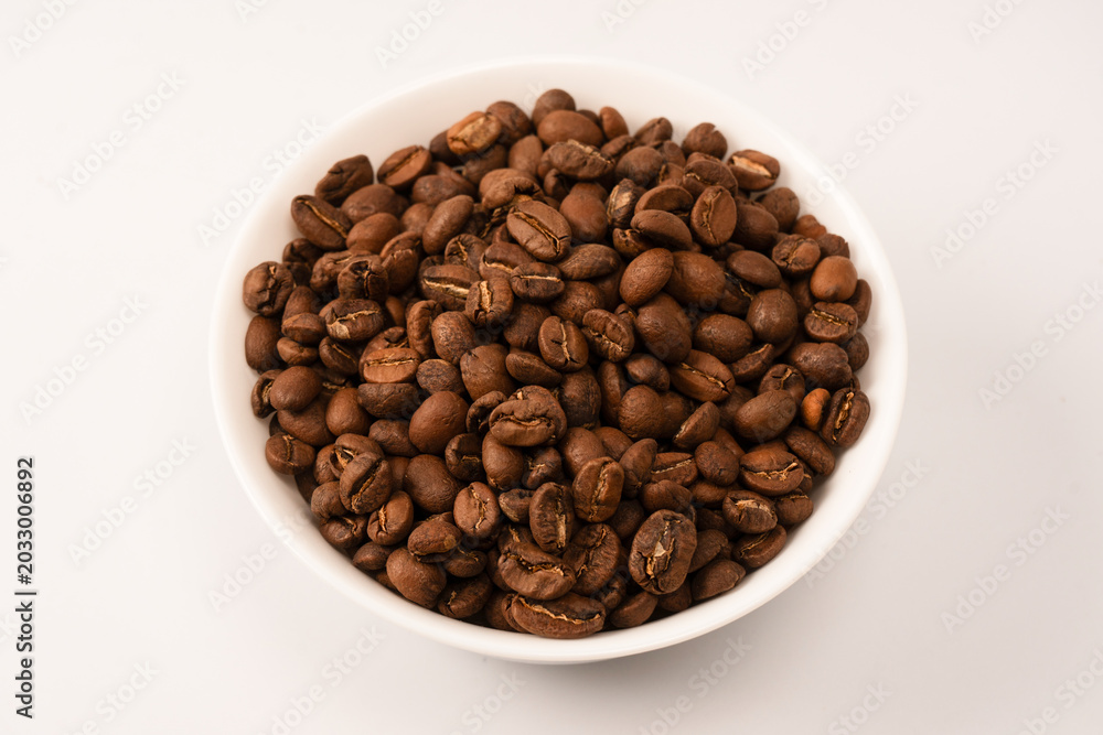 Fototapeta premium Coffee beans on a white background. Top view. Coffee beans texture.