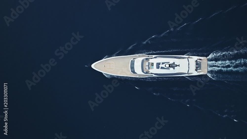 aerial top down view of superyacht with dolphin playing at bow in Bay of Kotor, Montenegro