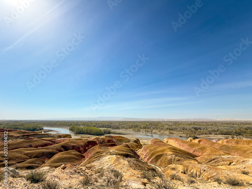 Stunning landscape of Wucaitan (Five Colored Hills) and the Irtysh River in Burqin, Xinjiang, China.