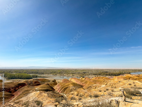 Stunning landscape of Wucaitan (Five Colored Hills) and the Irtysh River in Burqin, Xinjiang, China.