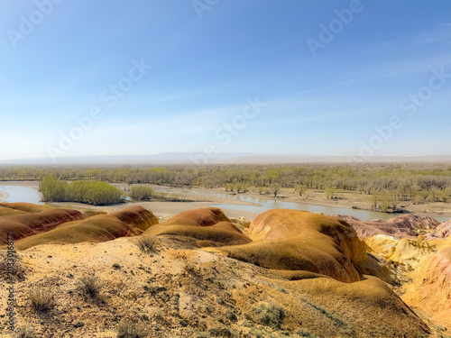 Stunning landscape of Wucaitan (Five Colored Hills) and the Irtysh River in Burqin, Xinjiang, China.