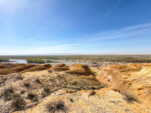 Stunning landscape of Wucaitan (Five Colored Hills) and the Irtysh River in Burqin, Xinjiang, China.
