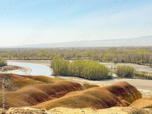 Stunning landscape of Wucaitan (Five Colored Hills) and the Irtysh River in Burqin, Xinjiang, China.
