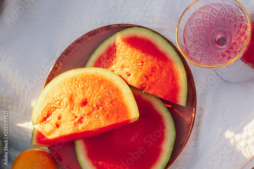 Quadro su tela Enjoying  sunny beach scene with fruit and  drink at sunset near water