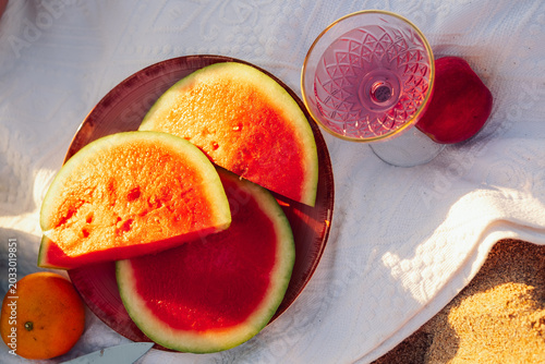 Fotografía Enjoying  sunny beach scene with fruit and  drink at sunset near water
