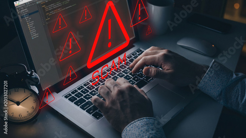 Fotografi Warning about a scam message on a laptop with alarming symbols at night