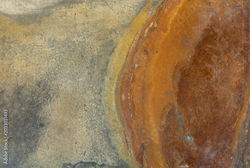 Natural rusty slate stone texture background with orange, brown, and grey colors. Top view full frame of rough mineral flagstone surface, abstract geological pattern