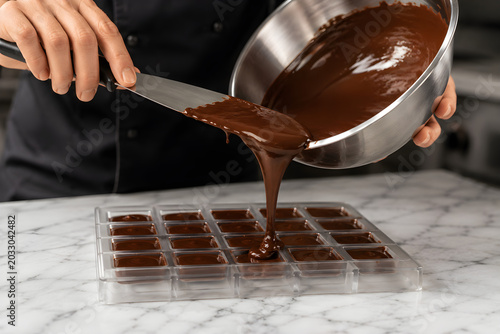 Pastry Chef Pouring Melted Chocolate Into Mold Tray for Confections
