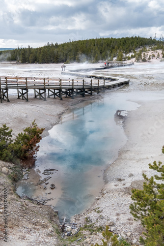 Yellowstone National Park, Wyoming, USA - May 13, 2017: Norris Geyser Basin boardwalk and geothermal pool at Yellowstone NP
