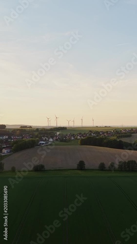 Vertical Aerial View of Village and Wind Turbines at Sunset